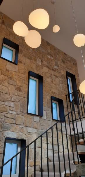 cage d'escalier avec pierre naturelle et encadrement de fenêtre métallique